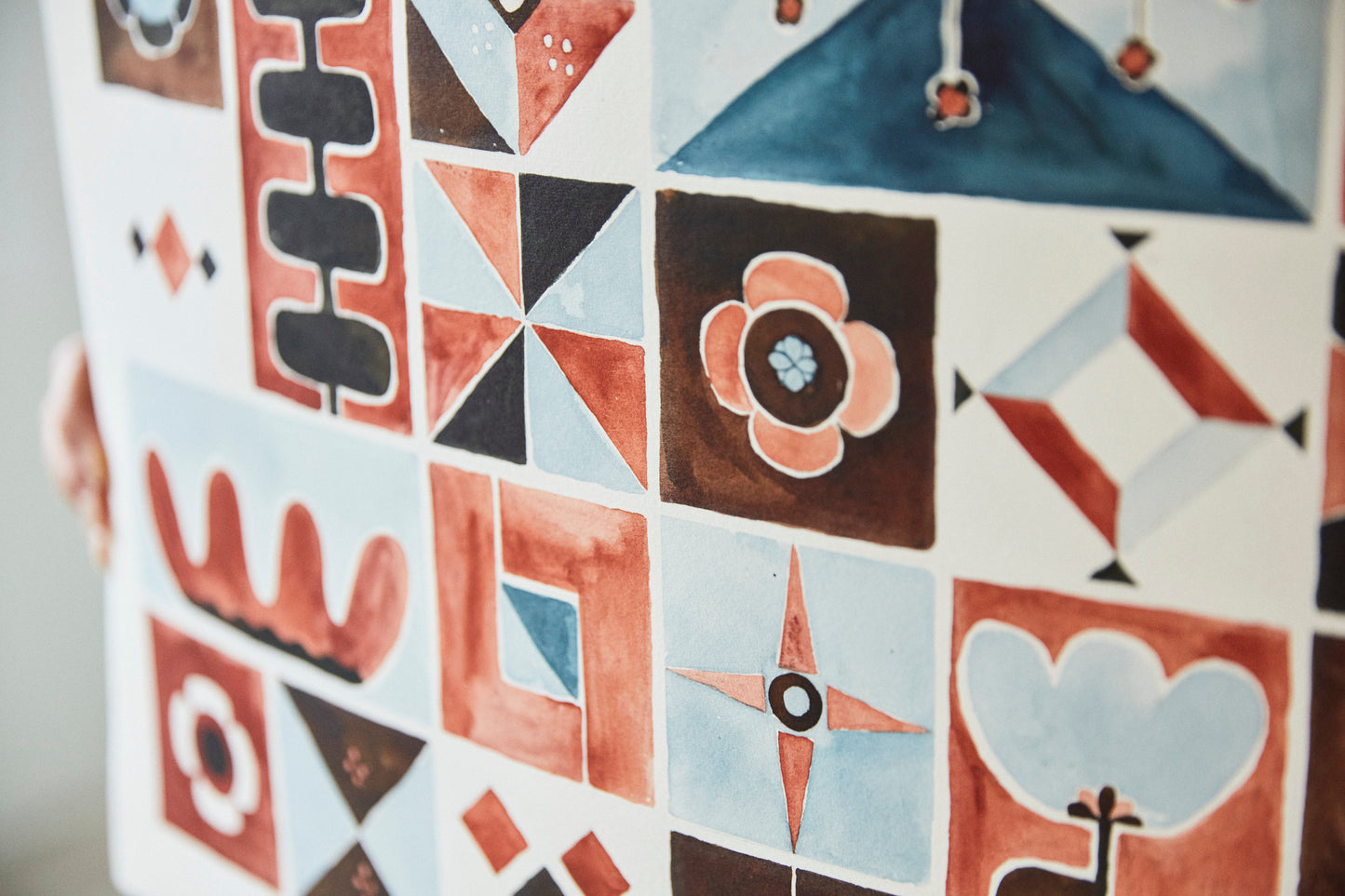 Detail of Austin watercolor artist Jaime Reynolds holds her folk patchwork terra cotta chestnut blue original painting